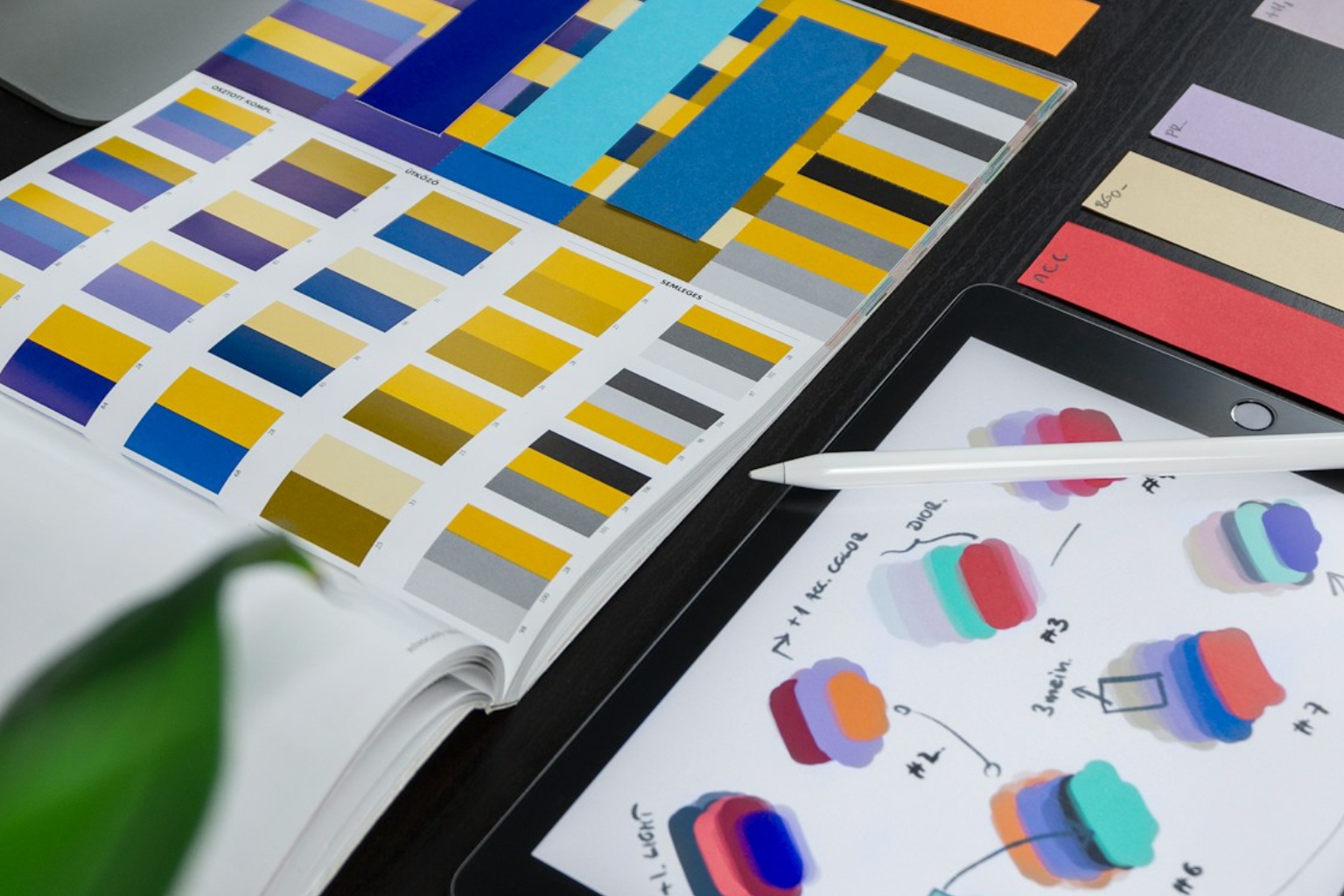 Mazzette di campioni colore e tablet grafico con schizzi di palette colore disegnati a mano
