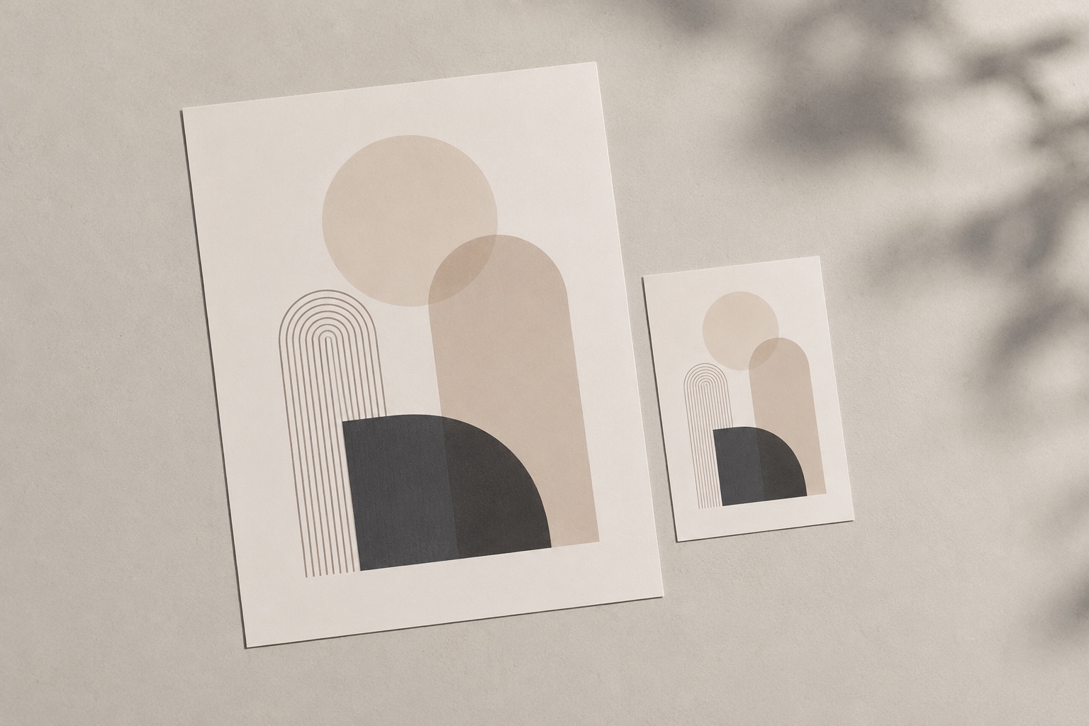 Due stampe artistiche astratte con cerchi e archi nei toni del beige, di formato diverso, appese a parete